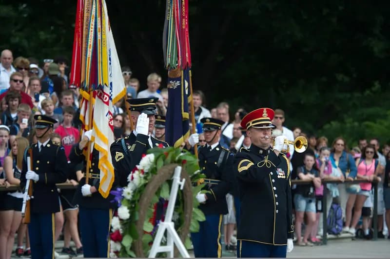 An Army bugler plays taps beside a wreath at Arlington National Cemetery